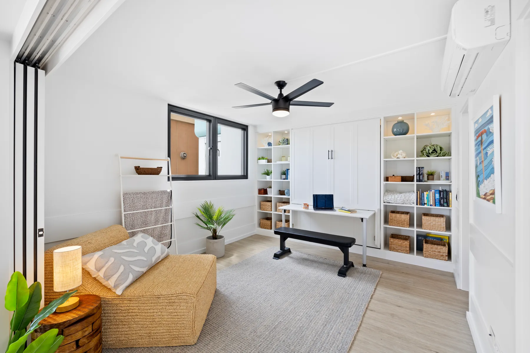Un dormitorio luminoso con una cama, un escritorio y estanterías empotradas.