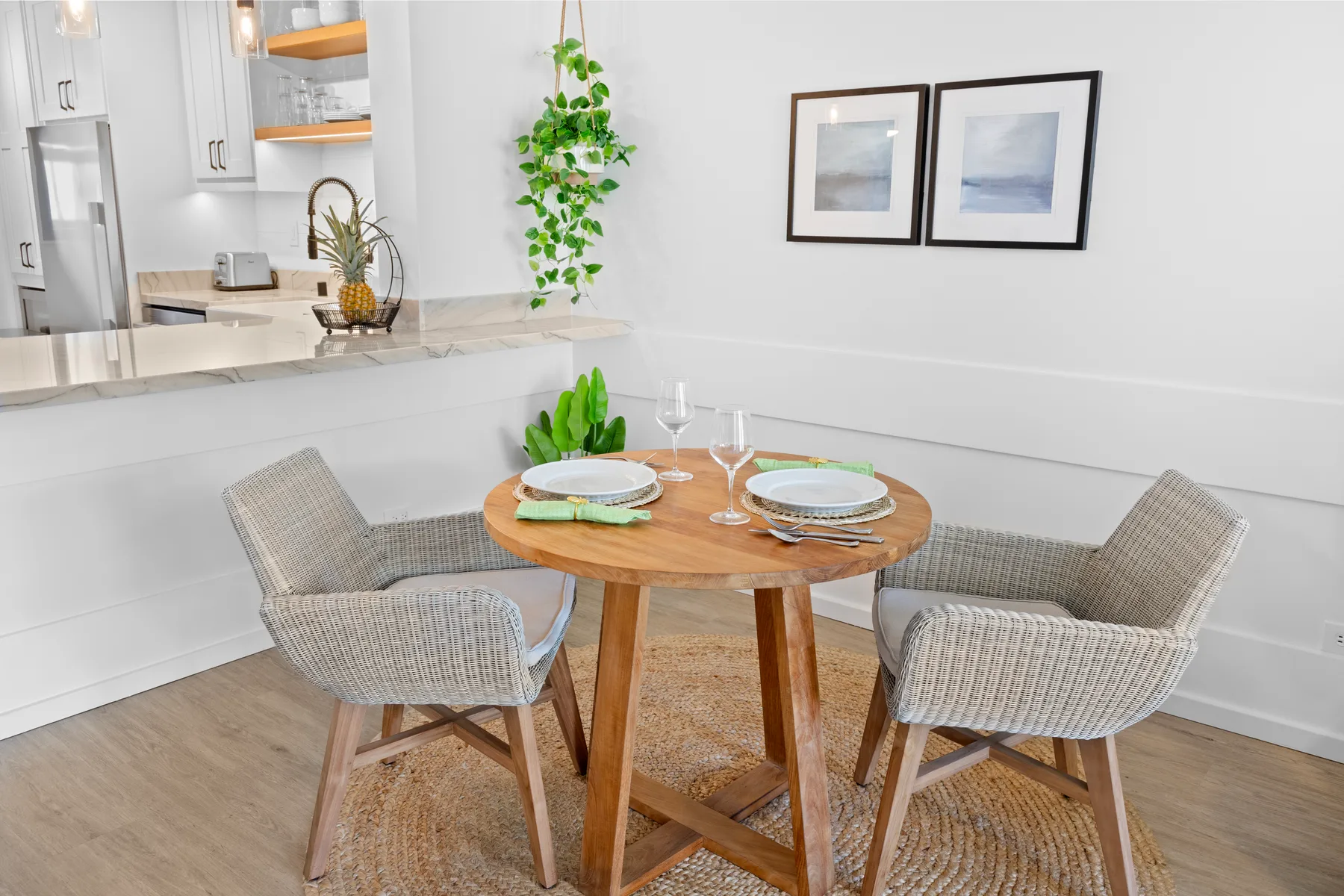 Un comedor con una mesa redonda puesta junto a una cocina abierta.