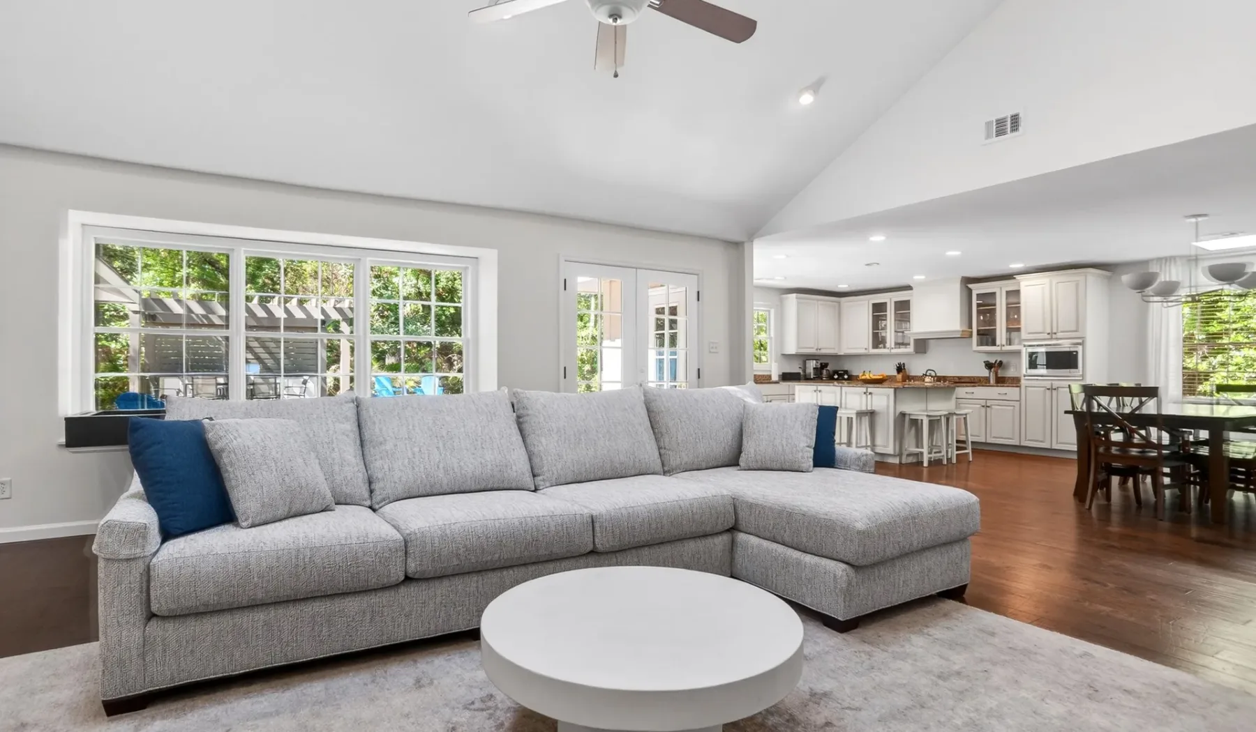 A living room with a gray sectional facing a round coffee table.