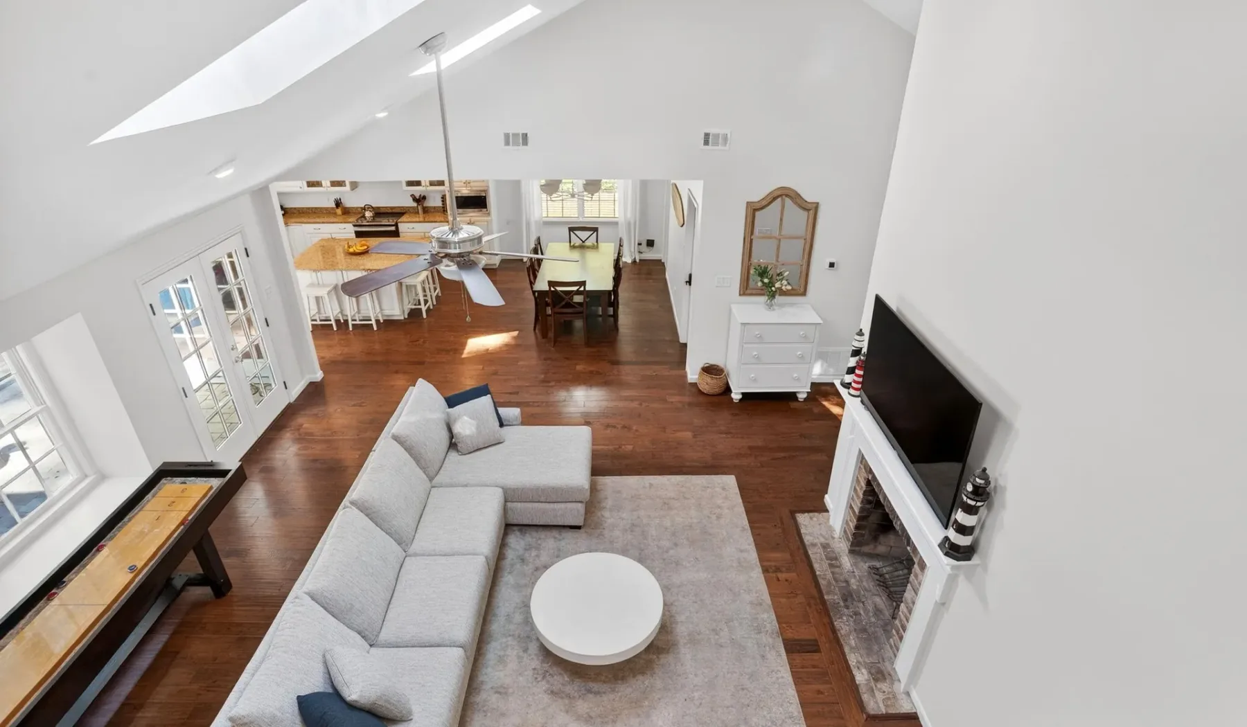 A bright living room with a sectional seating area and an open kitchen beyond.