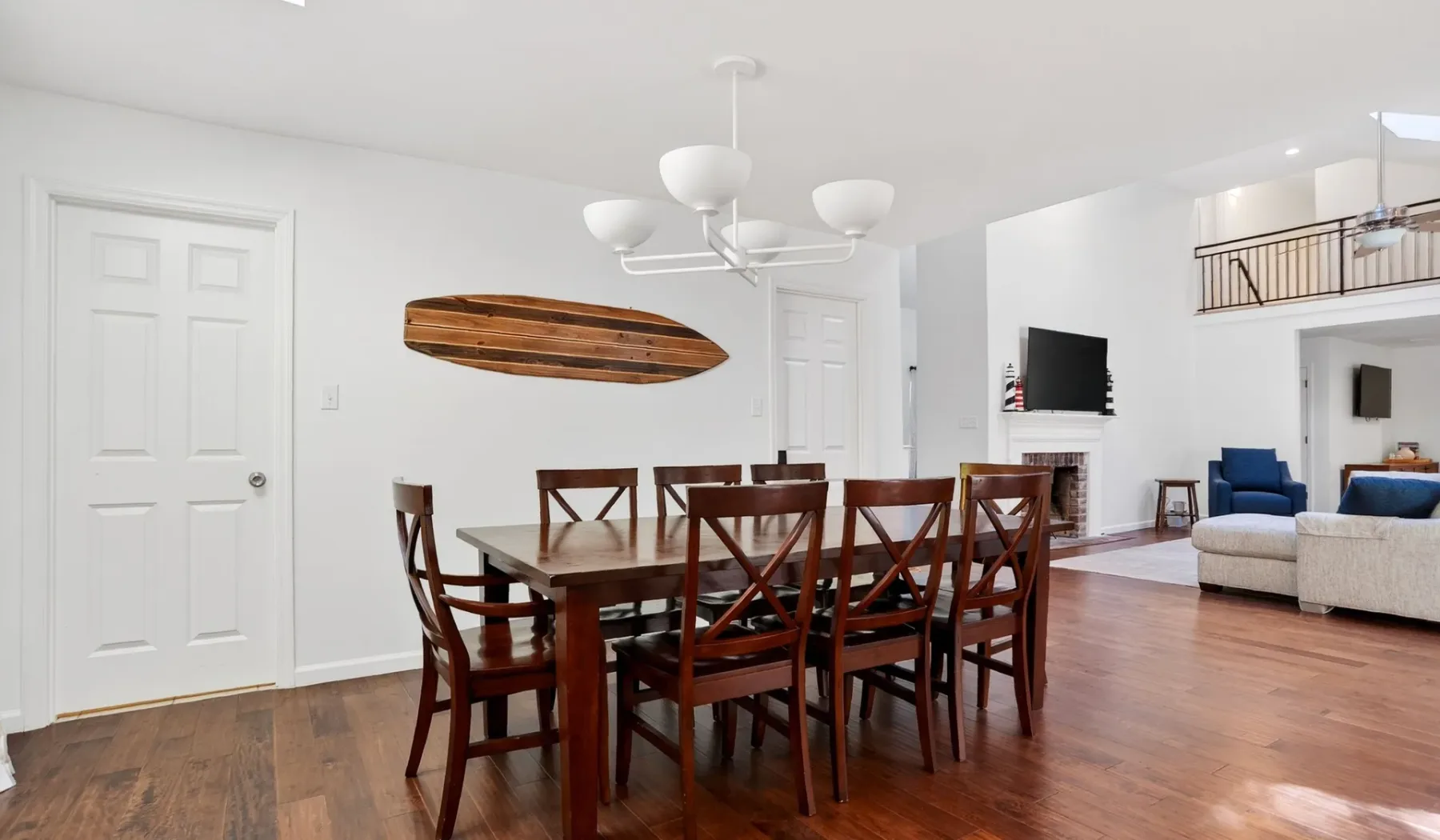 An open-plan dining and living area with a wooden dining table and seating.