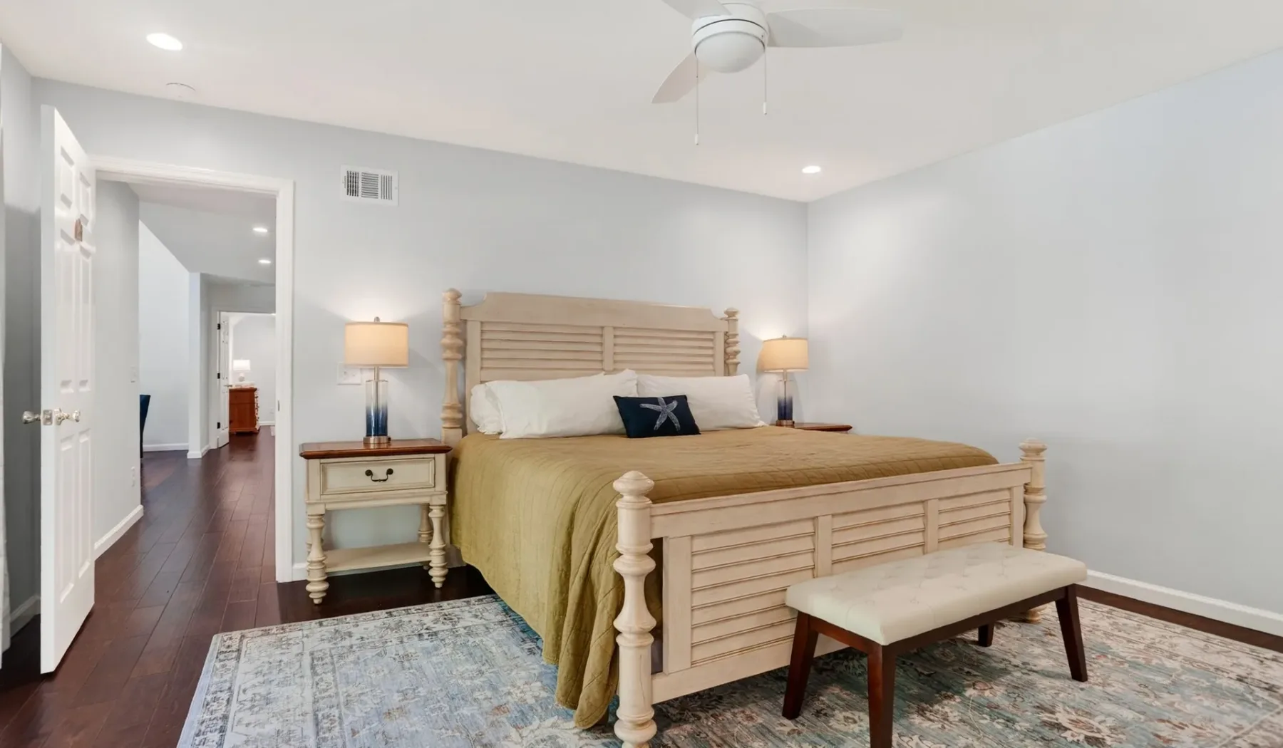 A bedroom with a wooden bed, bedside tables, and a rug.