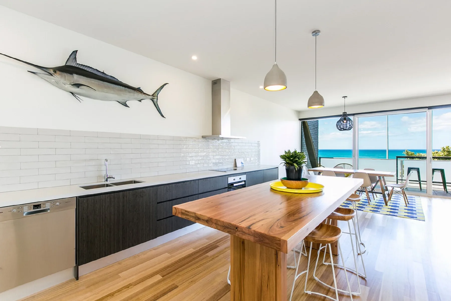 A bright kitchen and dining area opens onto a view of the ocean.