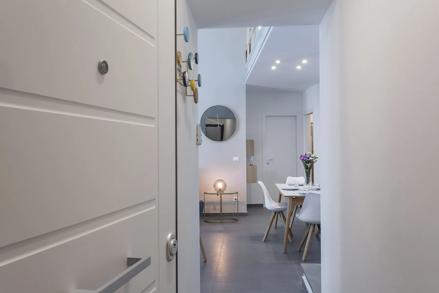 A bright dining area is visible through an open doorway, with a table and seating.