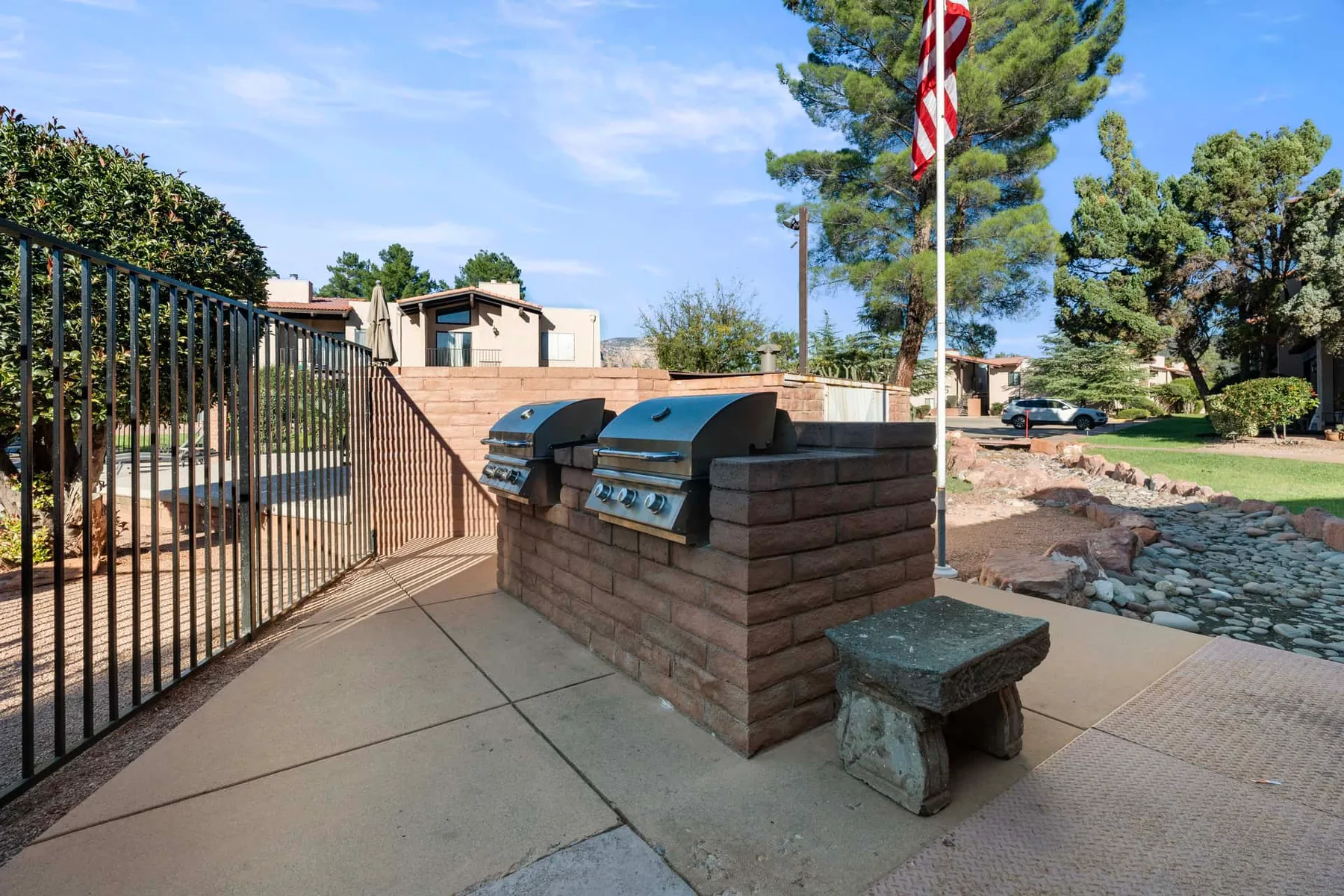 An outdoor barbecue area with built-in grills and a paved patio.