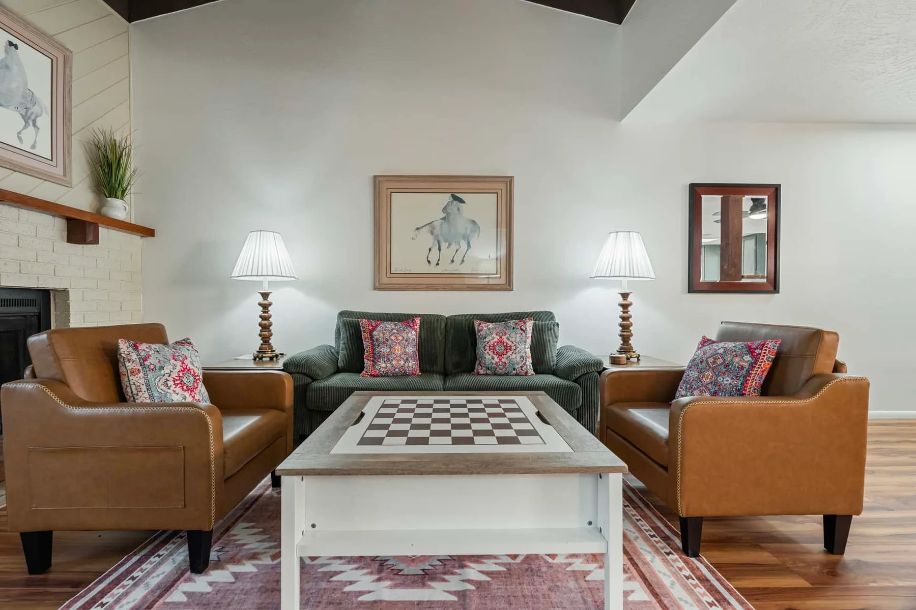 A living room with upholstered seating around a coffee table and two lamps.