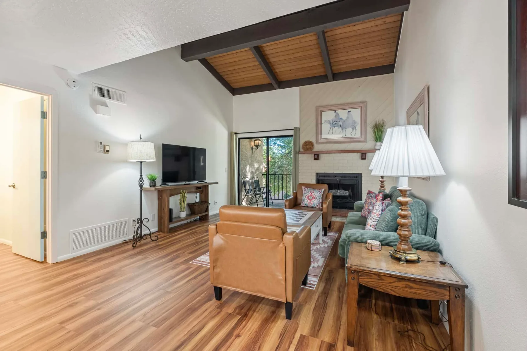 A living room with seating arranged around a coffee table and fireplace.