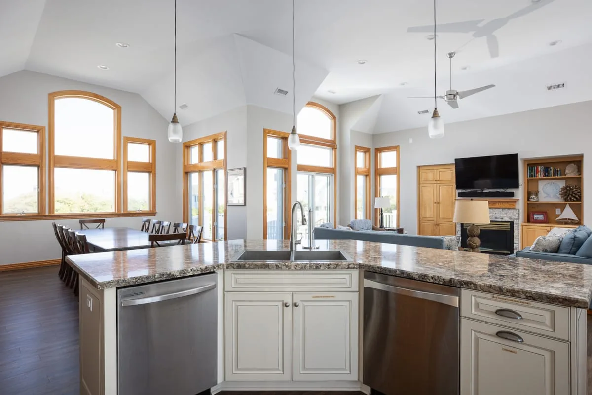 A bright open-plan kitchen and living area with large windows and a central island.