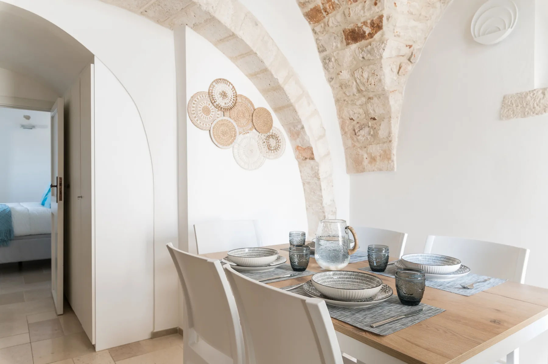 Un comedor con una mesa de madera bajo un arco de piedra.