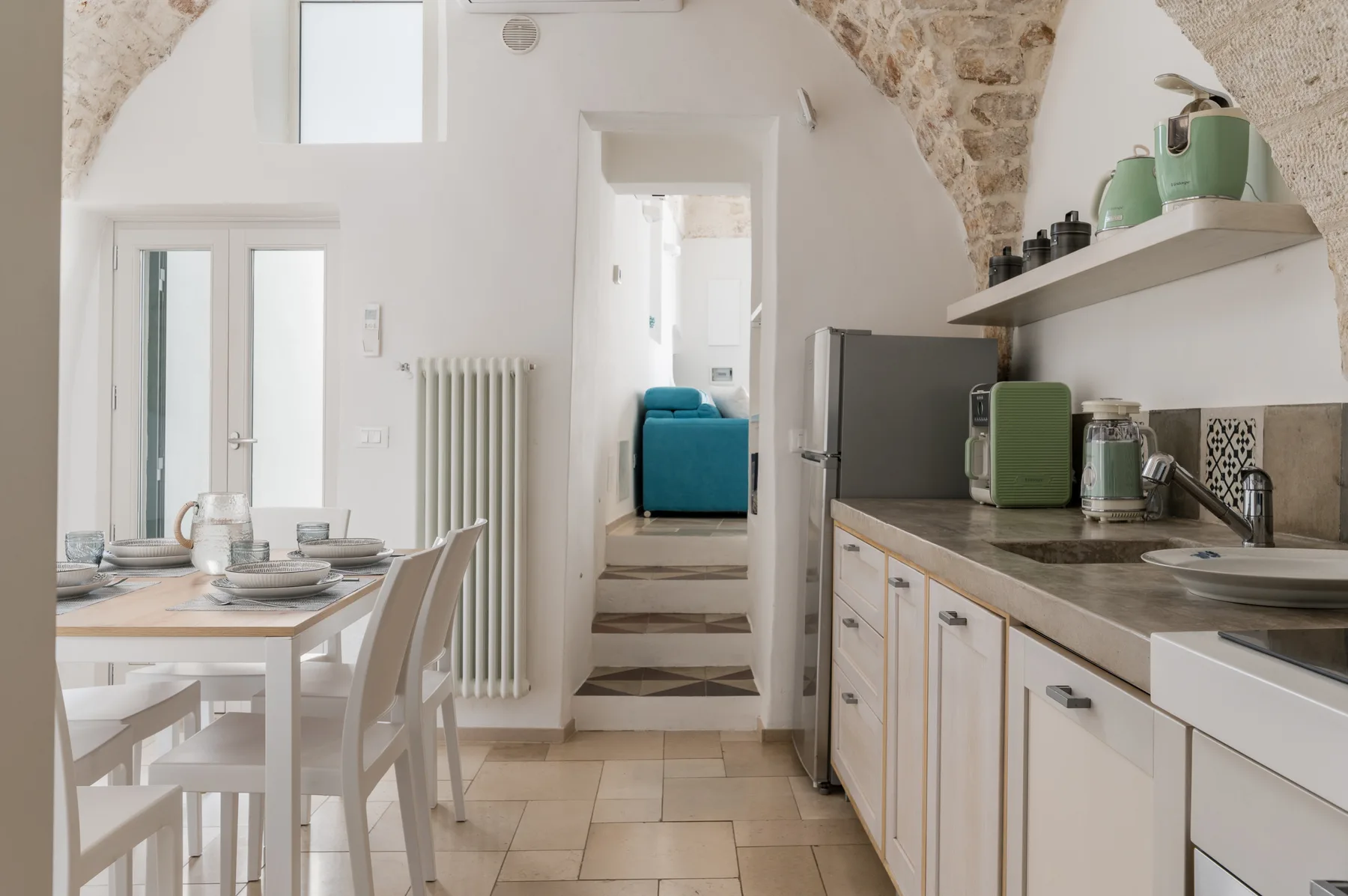Una cocina luminosa con comedor y una mesa junto a la encimera.