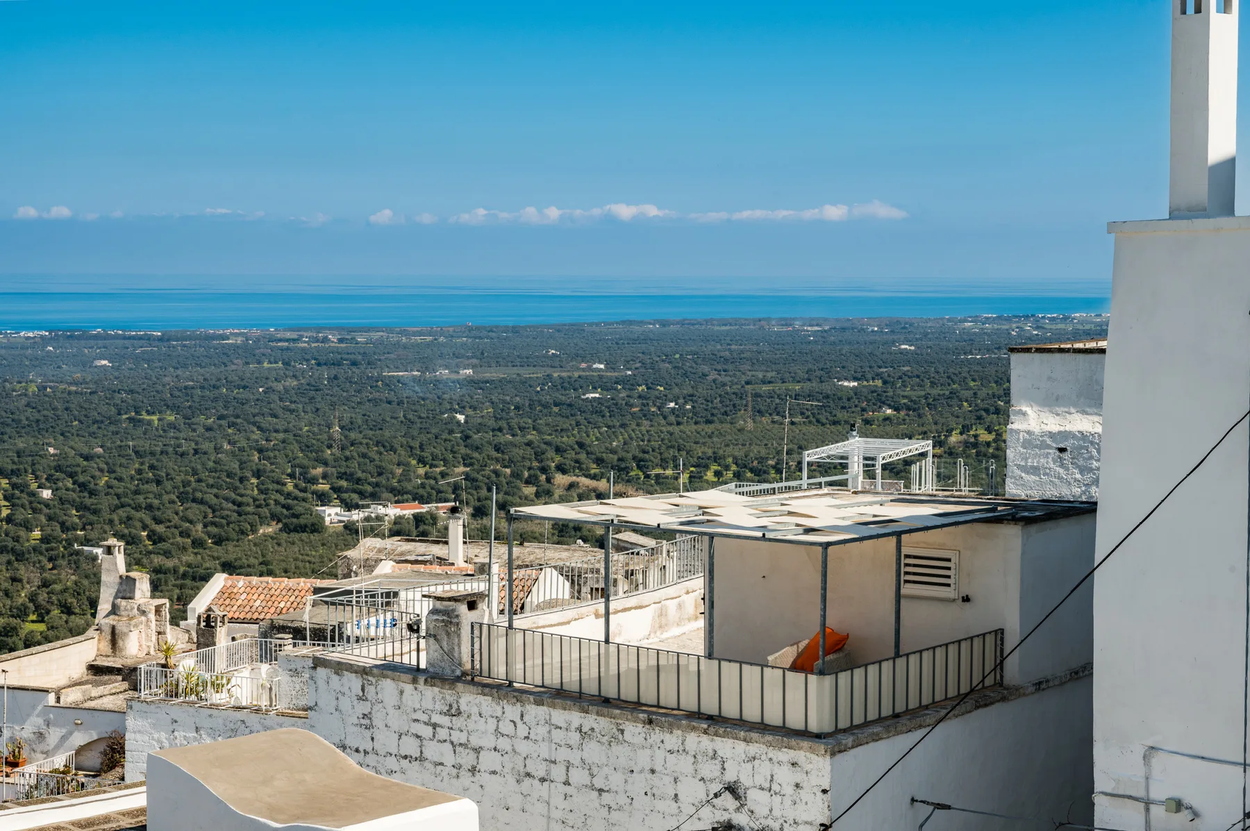 Una terraza en la azotea domina un amplio paisaje y el mar.