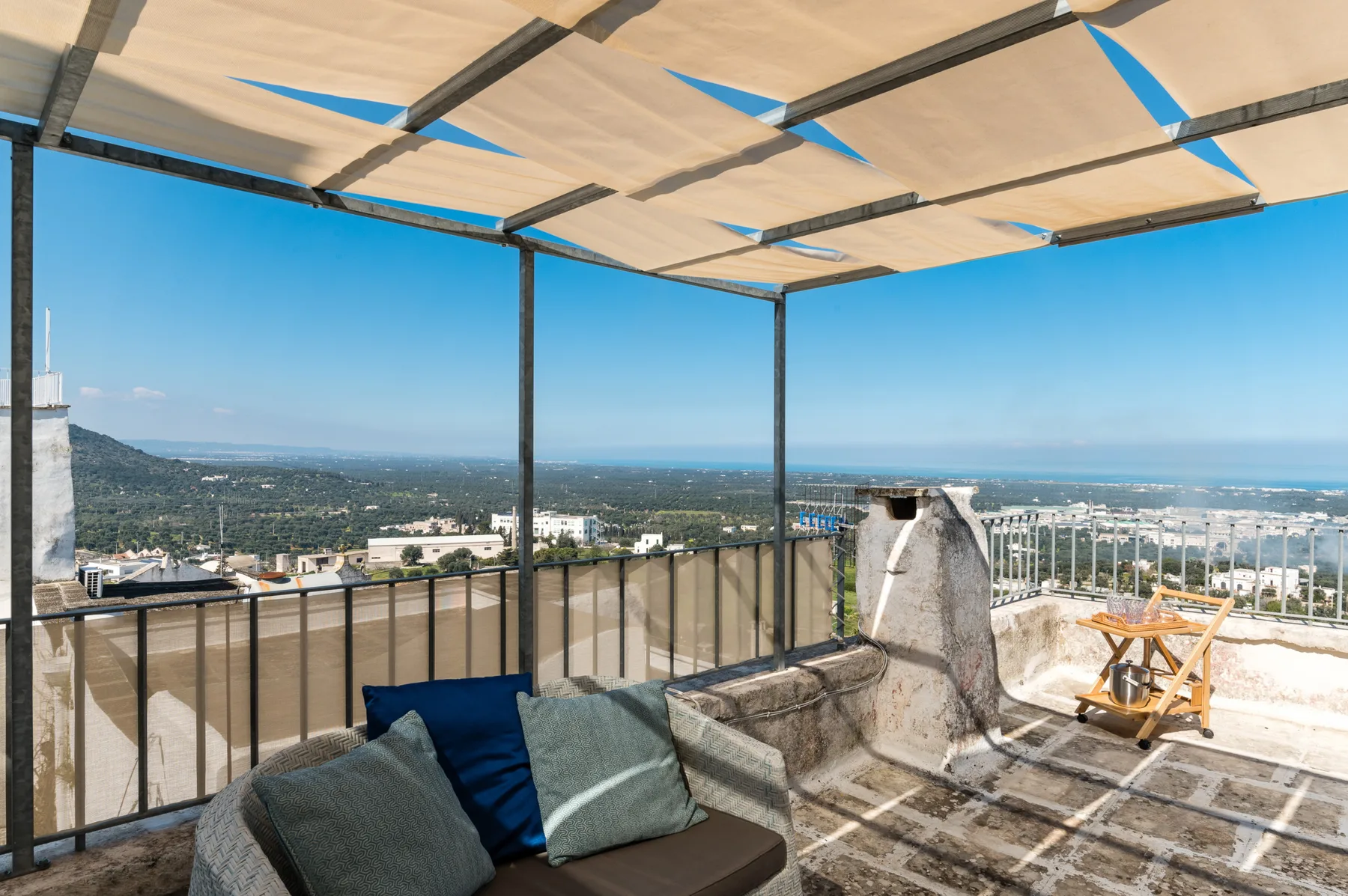 Una terraza en la azotea con asientos y vistas amplias del paisaje circundante.