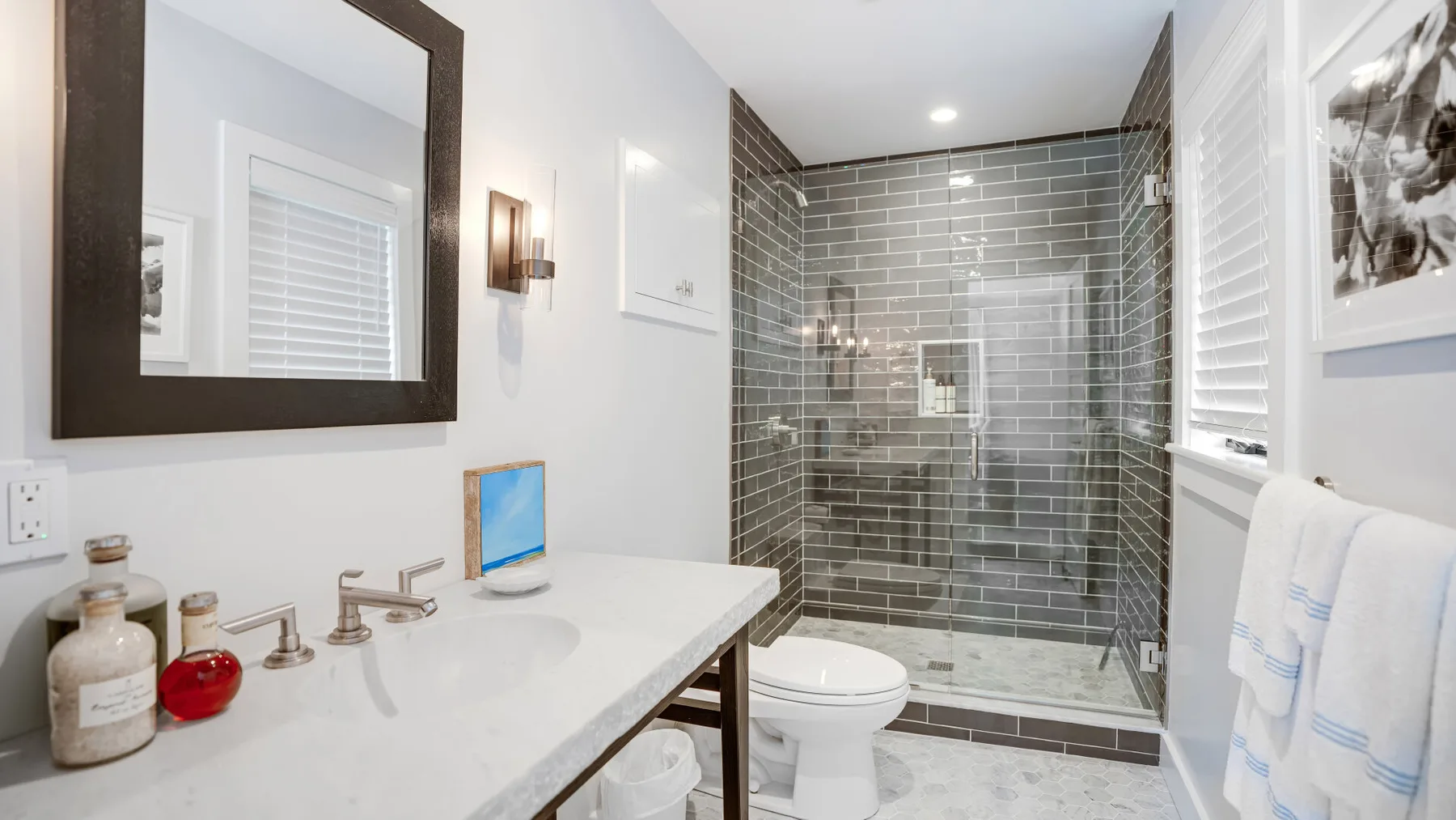 A bathroom with a sink, toilet, and glass-enclosed shower.