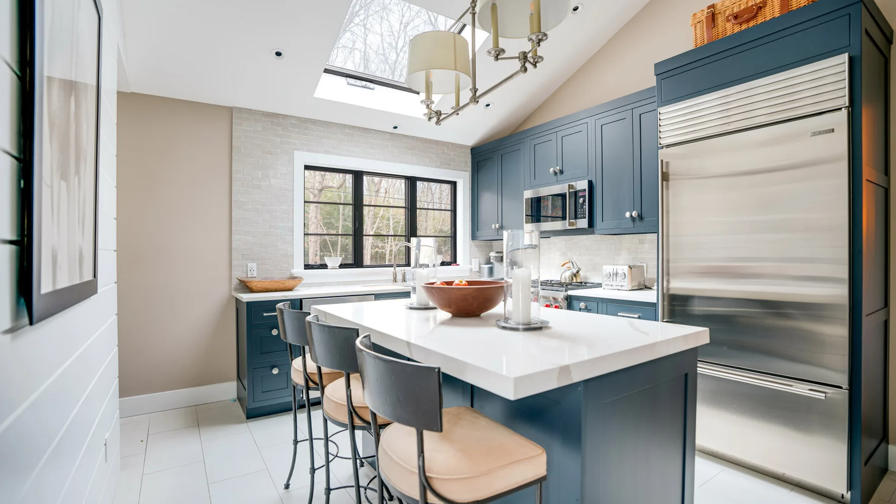 A bright kitchen with blue cabinetry and a large central island.