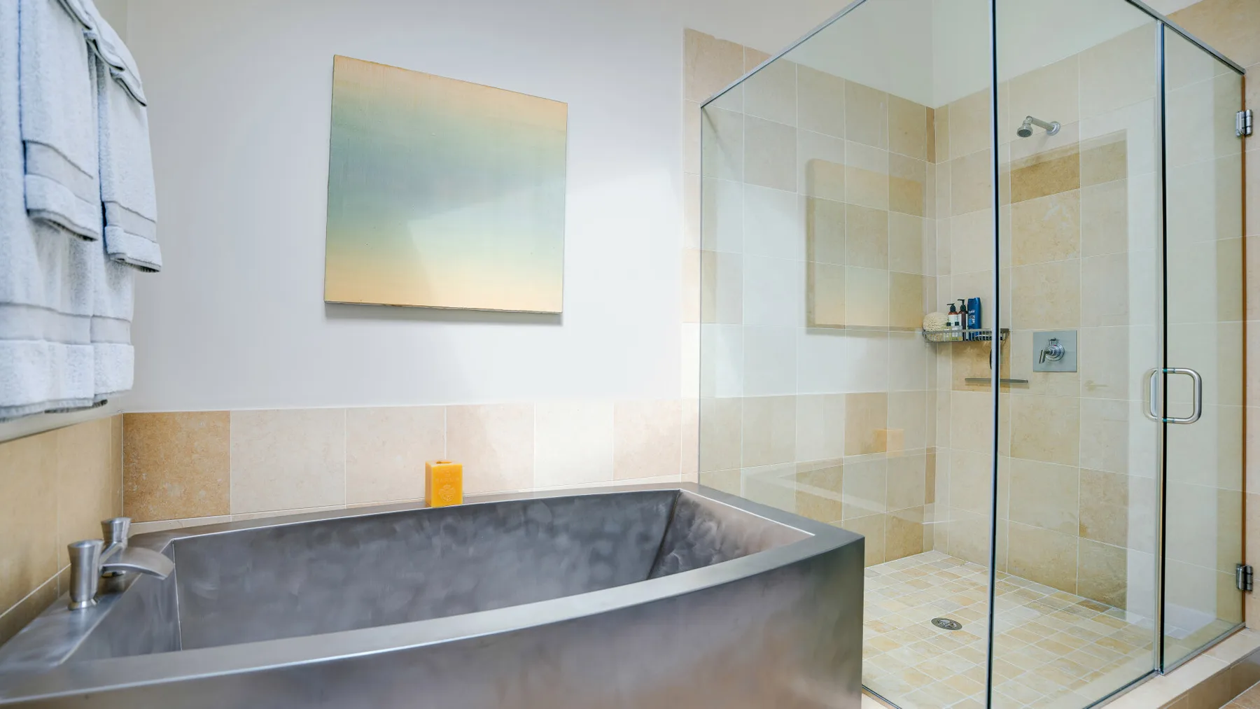 A bathroom with a bathtub, glass shower, and neutral tile.