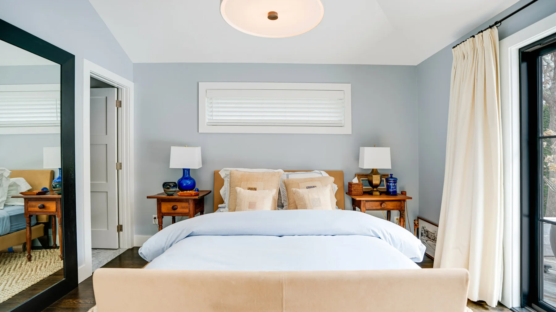 A bedroom with a neatly made bed and matching bedside tables.