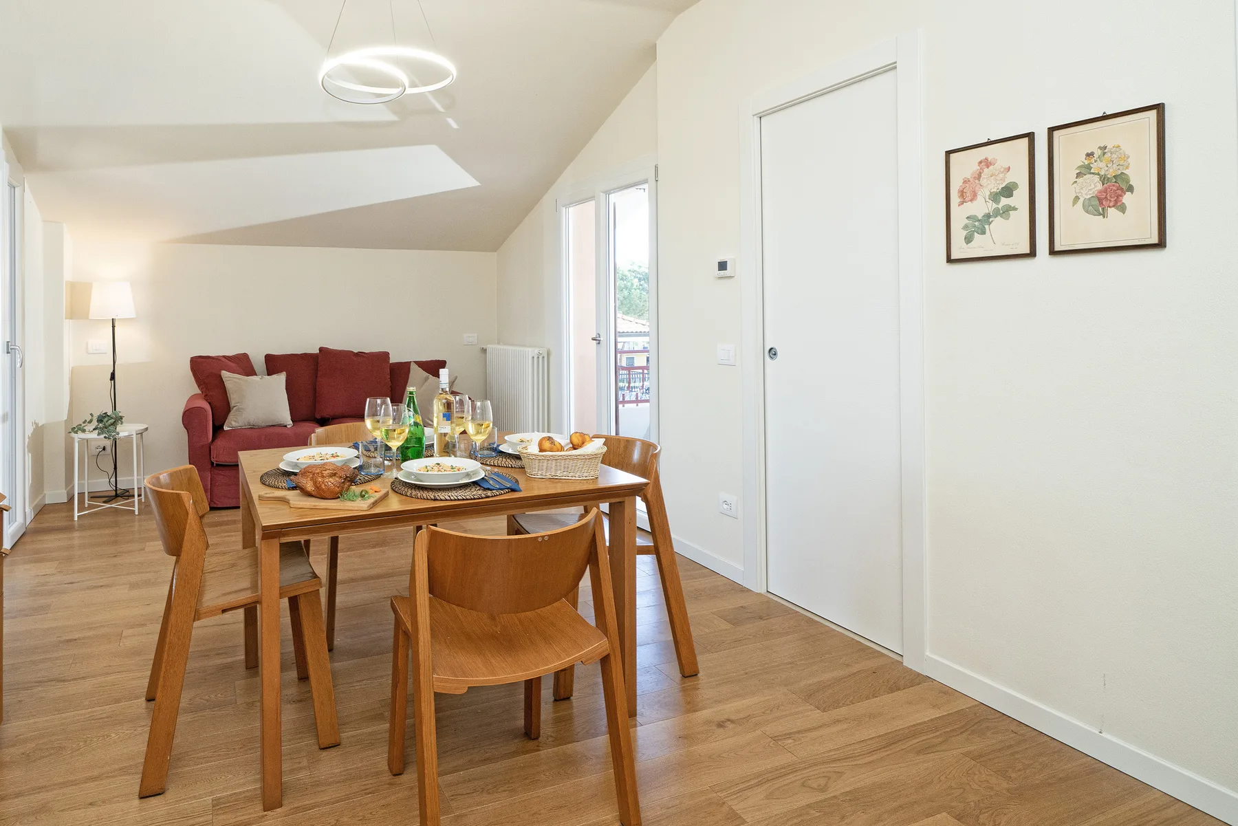 A dining area with a set table and red seating in a bright room.