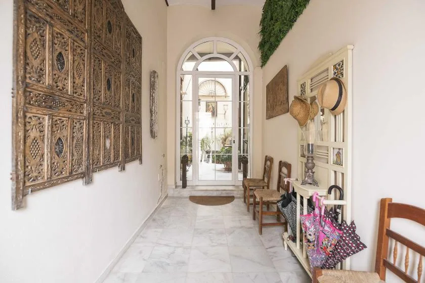 A bright entry hall with an arched glass doorway and decorative wall panels.