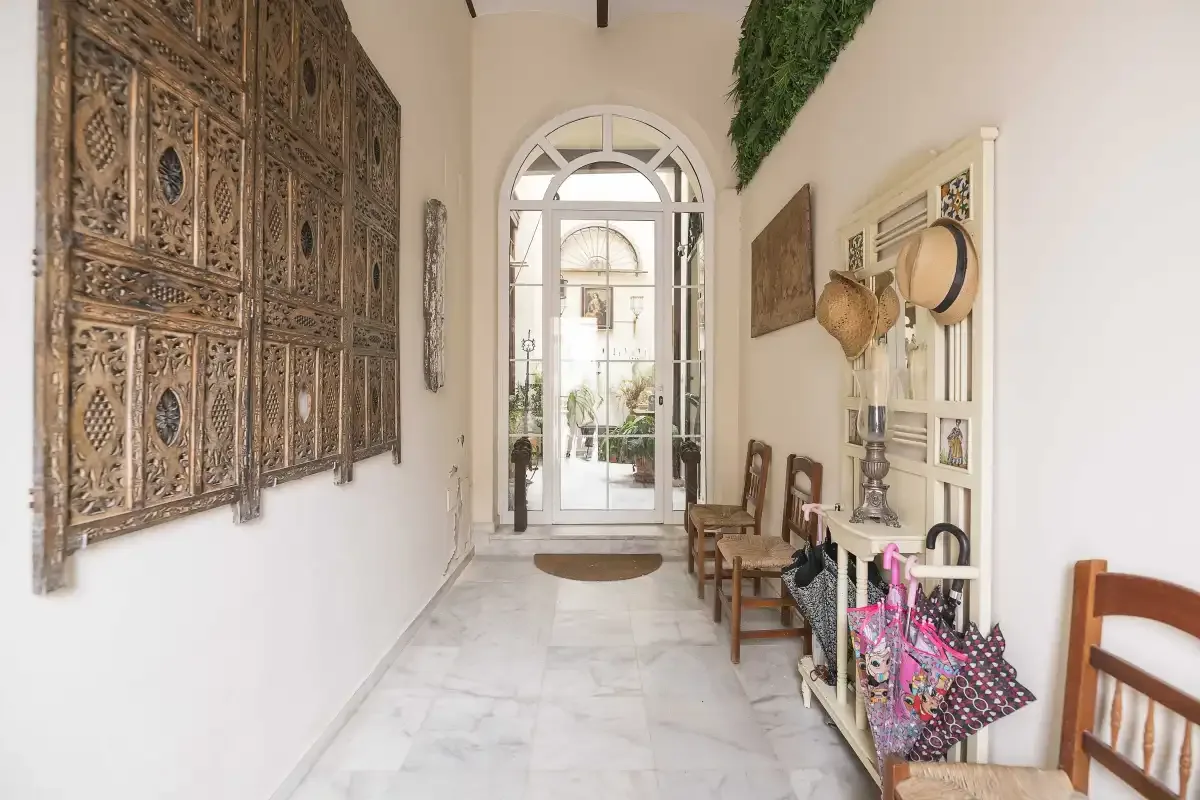 A bright entry hallway with an arched glass doorway and decorative wall panels.