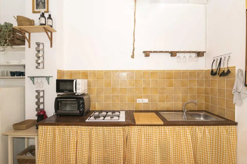 A kitchen counter with a stovetop, sink, and small appliances.