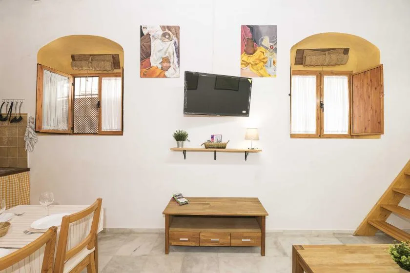 A living room with a wall-mounted television above a wooden table.
