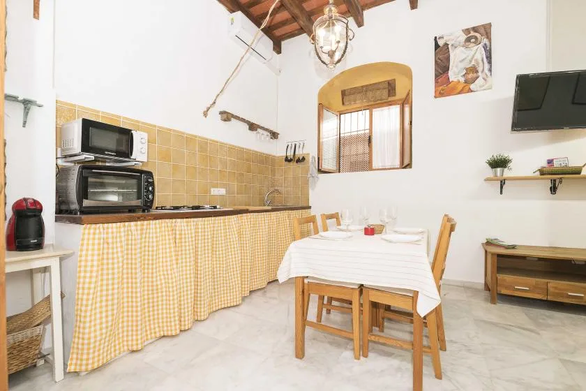 A dining area with a table and chairs beside a tiled kitchen counter.