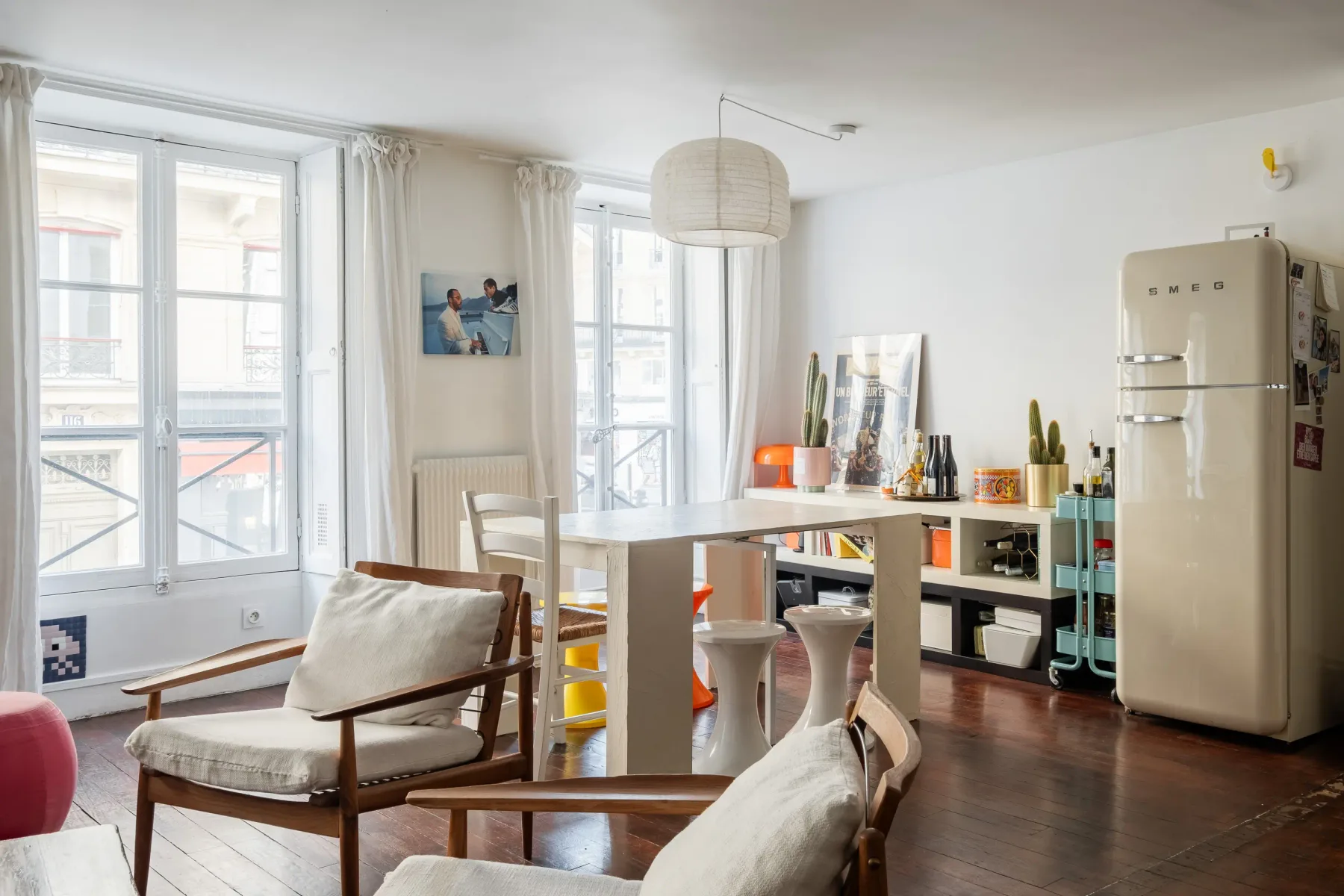 Una luminosa sala de estar y comedor con grandes ventanas y una mesa.