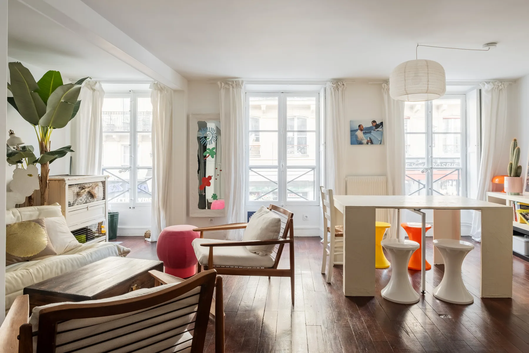 Una luminosa sala de estar y comedor con ventanas grandes y una mesa.