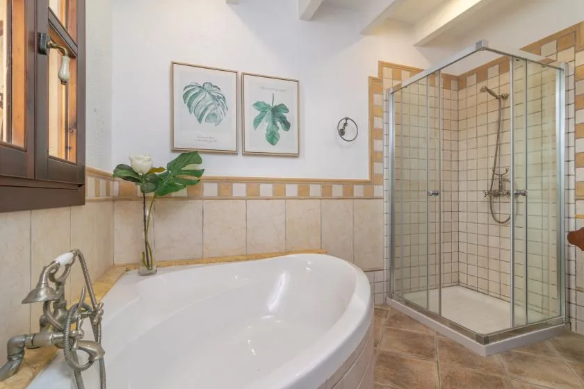 A bathroom with a large bathtub and a glass-enclosed shower.