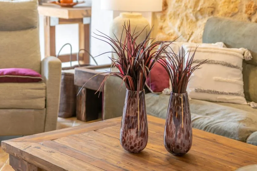 A living room seating area with two decorative vases on a wooden coffee table.