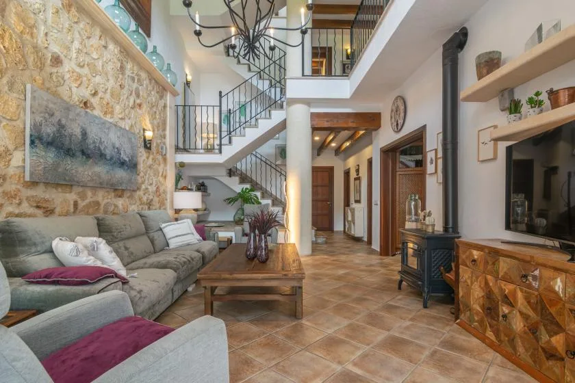 A living room with seating beneath a tall open staircase and loft.