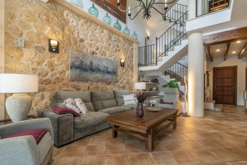 A living room with seating, a wooden coffee table, and a staircase.