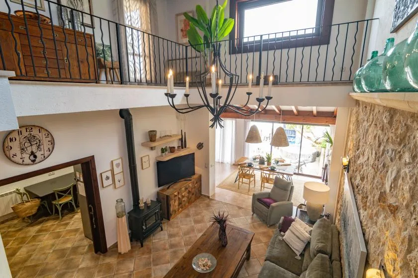 A double-height living room with seating, a fireplace, and a chandelier.