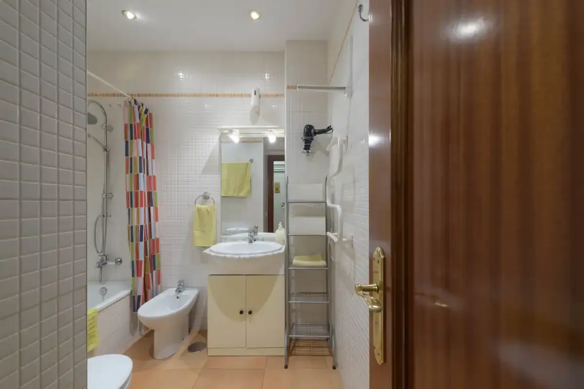 A bathroom with a sink, toilet, and colorful shower curtain.