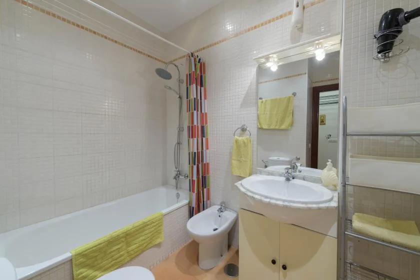 A tiled bathroom with a bathtub, shower, and sink.