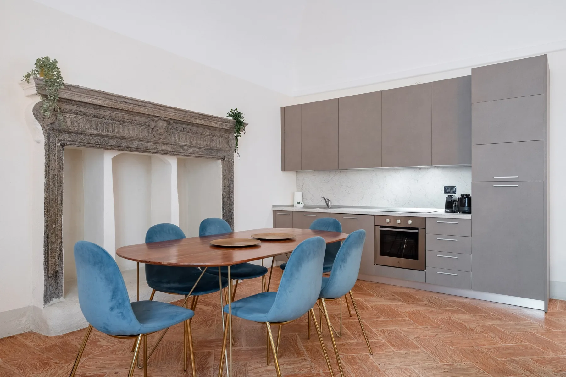 Comedor con asientos azules junto a una cocina moderna.