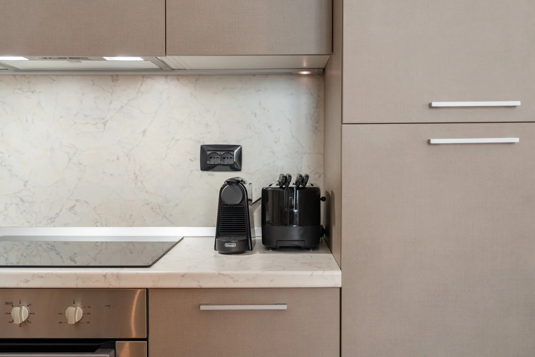 Una encimera de cocina moderna con pequeños electrodomésticos y gabinetes claros.