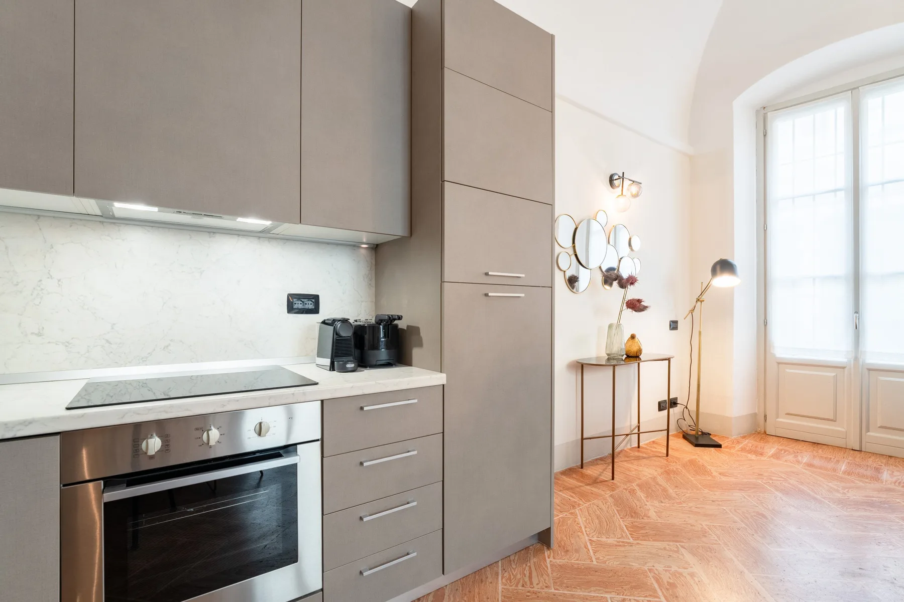 Una cocina moderna con armarios y encimera está junto a una ventana luminosa.