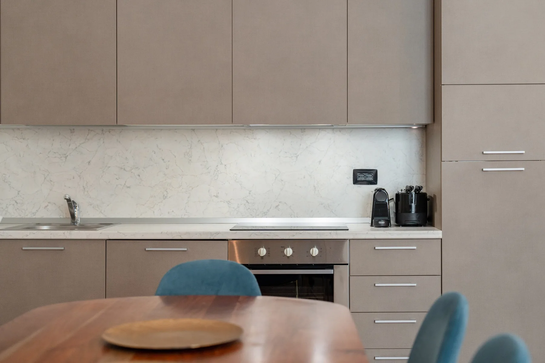 Una cocina moderna con electrodomésticos integrados y una mesa de comedor en primer plano.