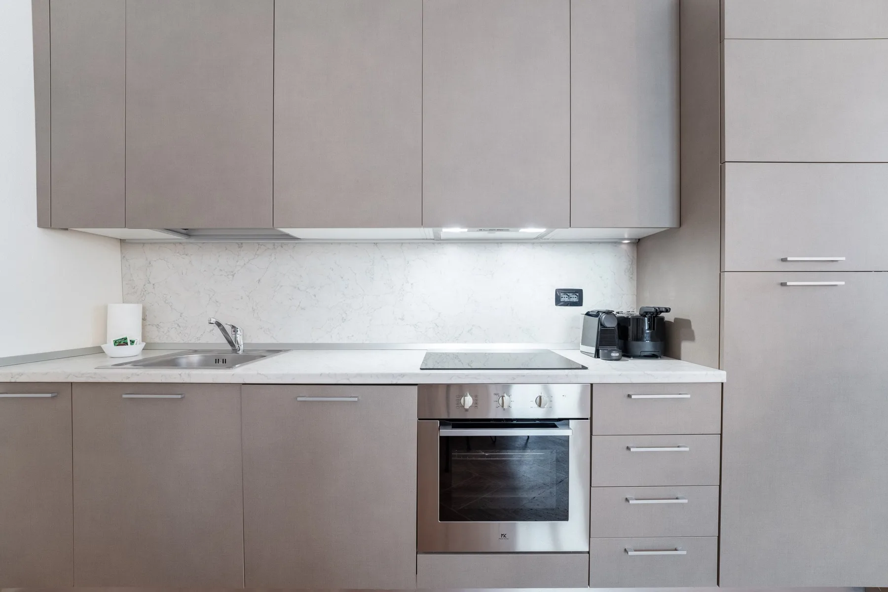 Una cocina moderna con armarios, una placa de cocción y un horno.