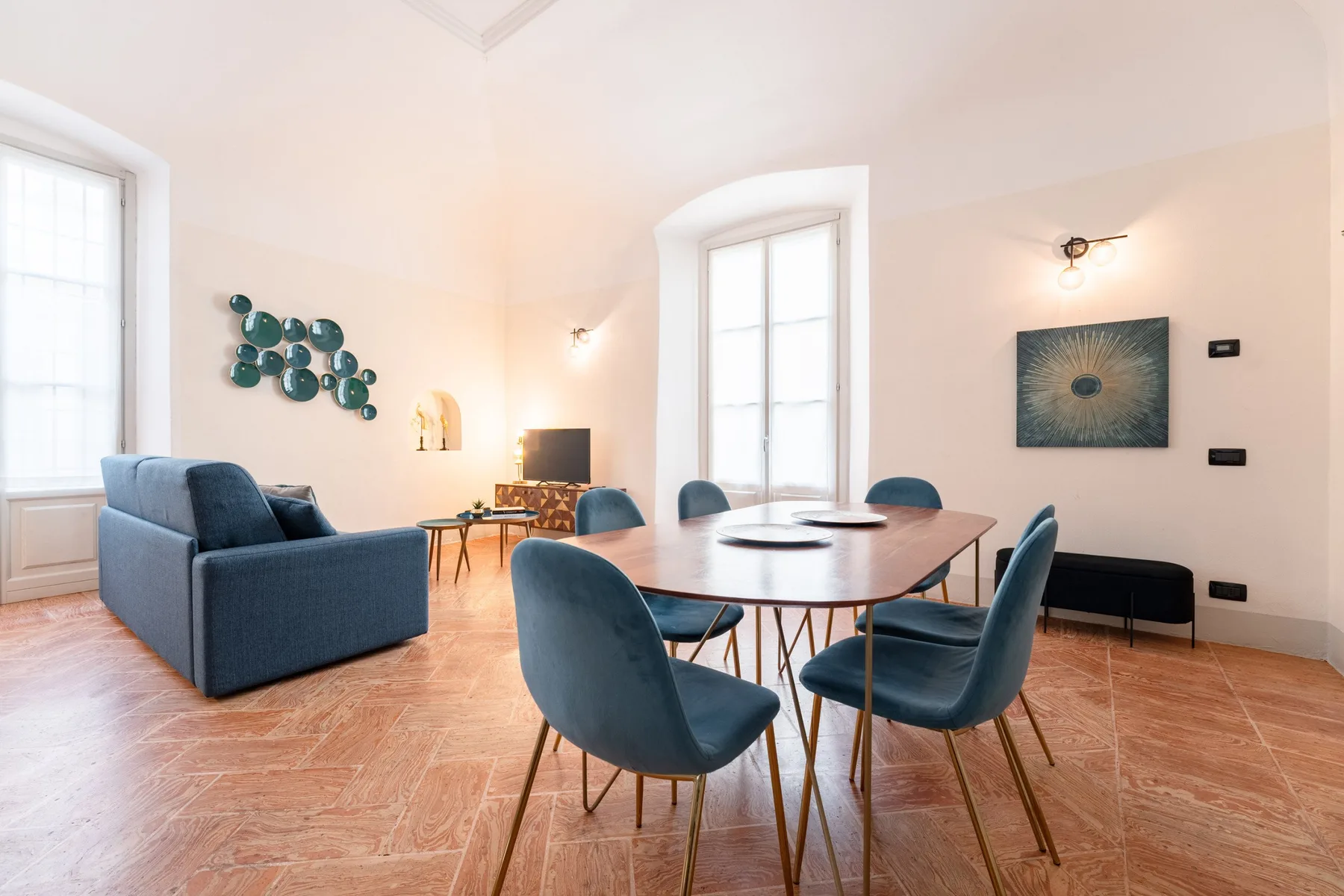 Un comedor con una mesa larga y asientos tapizados en azul.