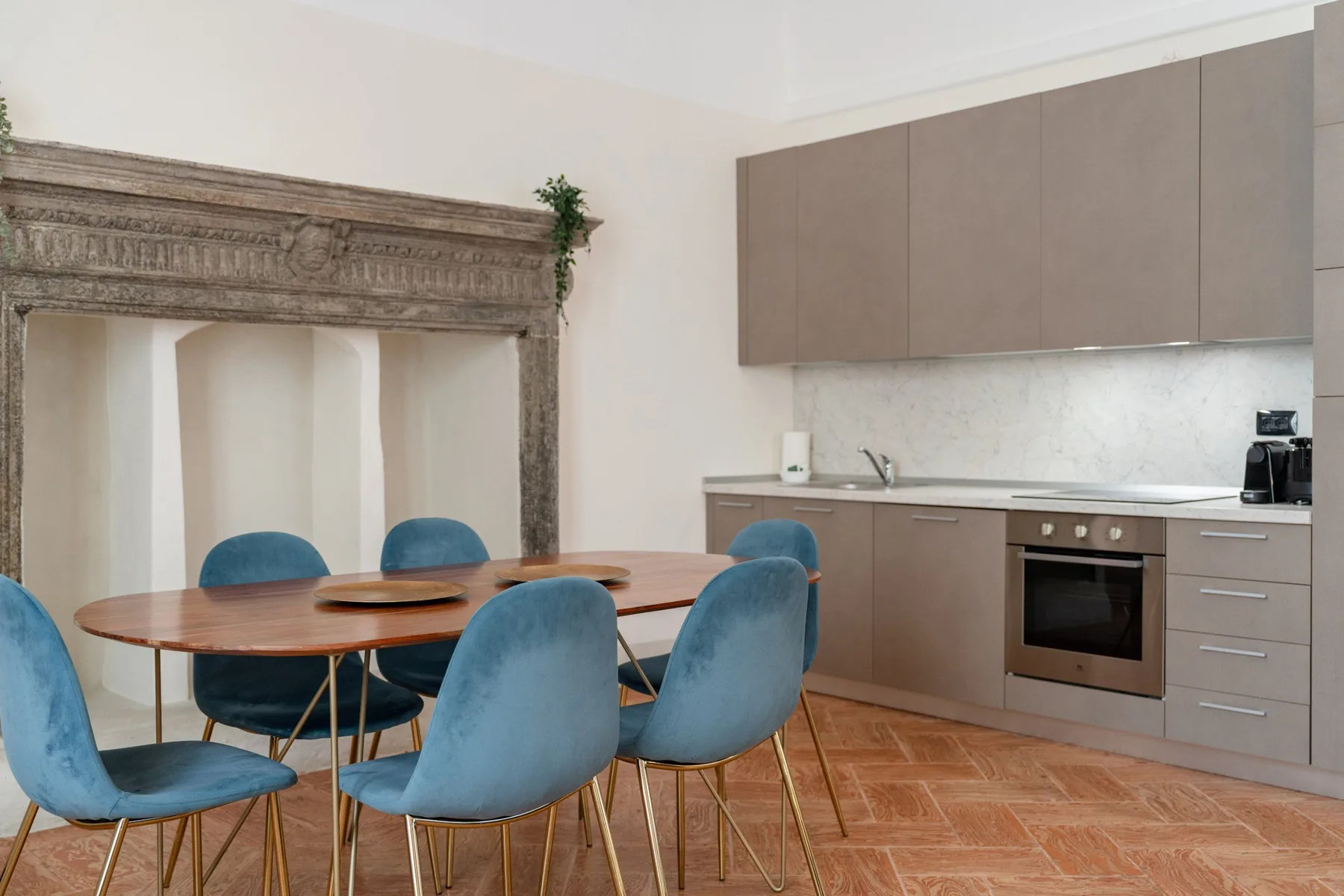 Un comedor con una mesa redonda y una cocina junto a la pared.