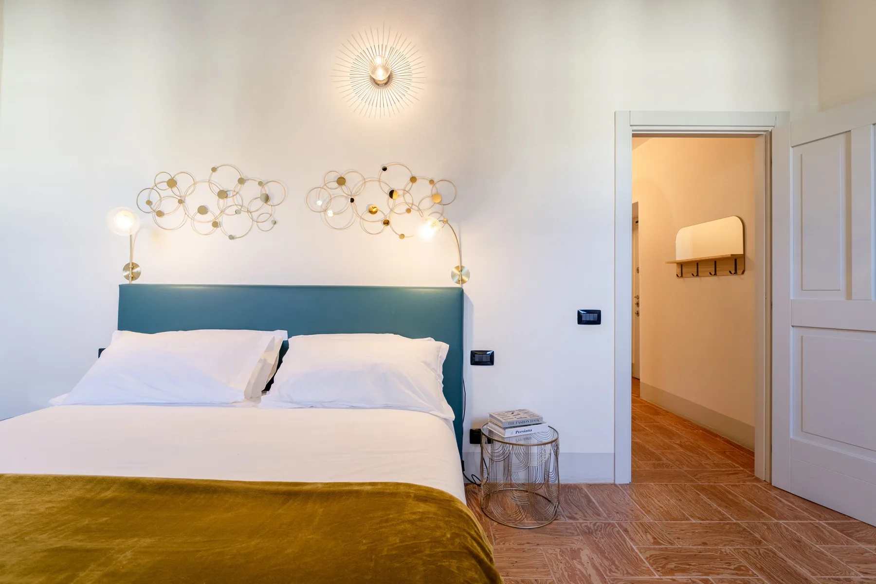 Un dormitorio con una cama bien tendida y una puerta abierta.