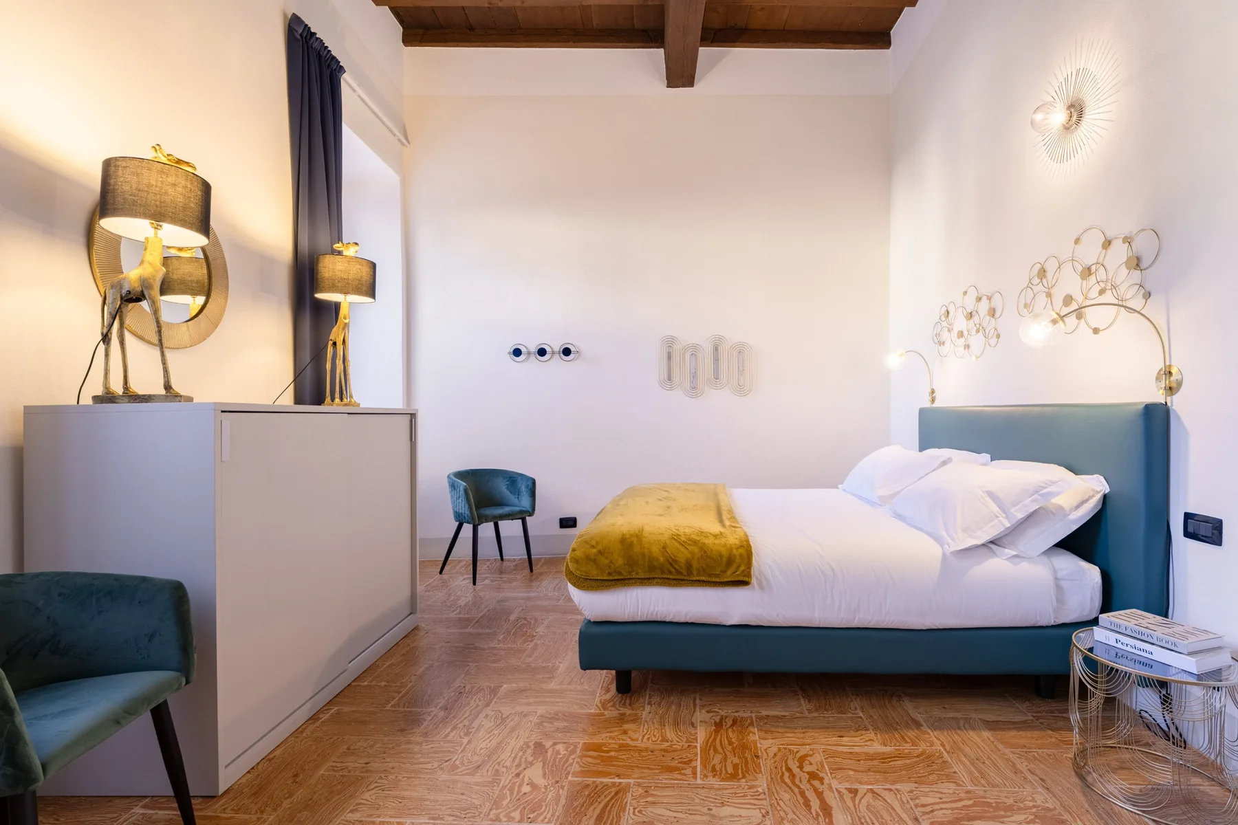 Un dormitorio con una cama, una mesa auxiliar y asientos tapizados.