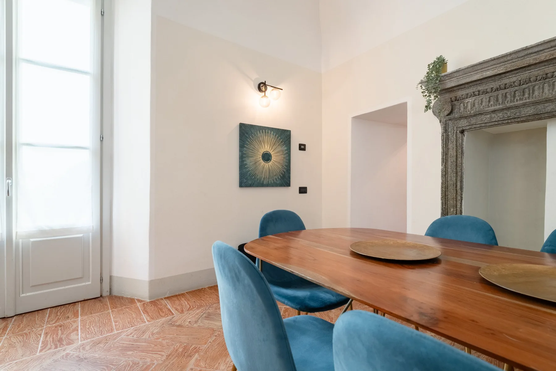 Un comedor con una mesa de madera y asientos tapizados en azul.