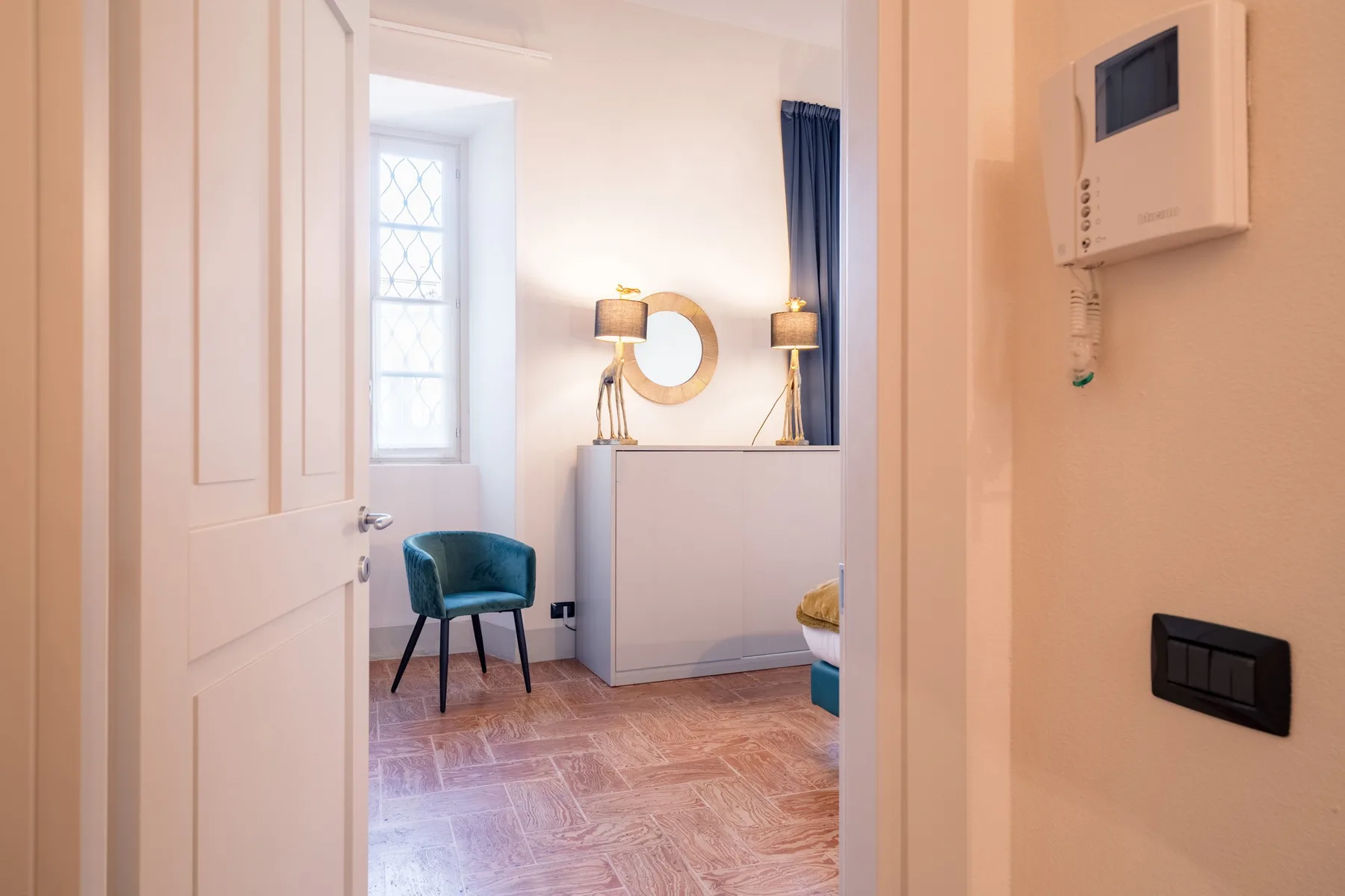 Un dormitorio luminoso con un escritorio, una silla y una ventana.