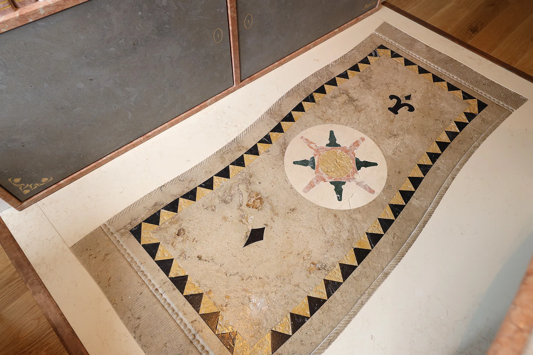 A decorative floor tile features a patterned border and central motif.