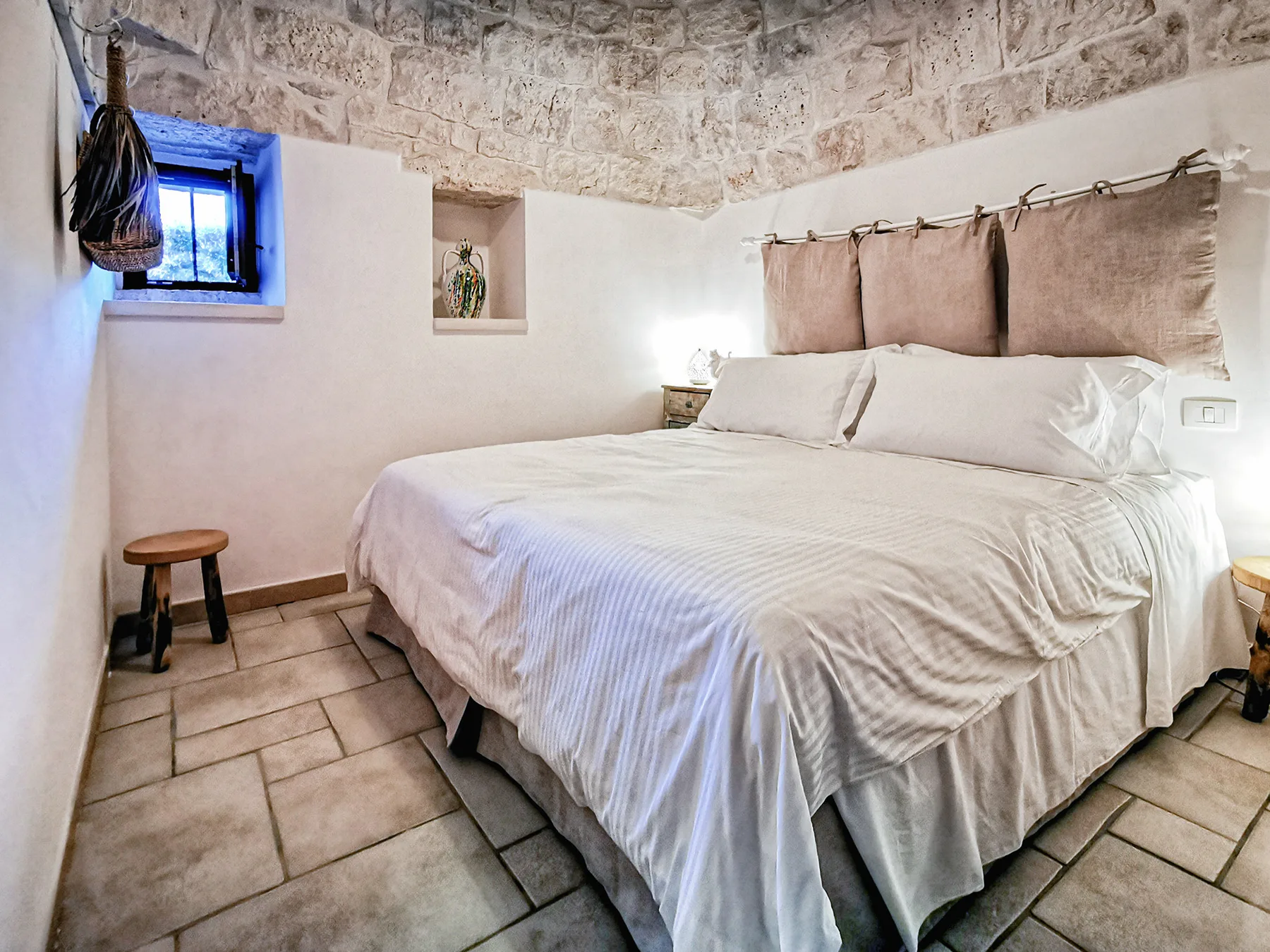 Un dormitorio con una cama grande bajo una ventana con cortinas.
