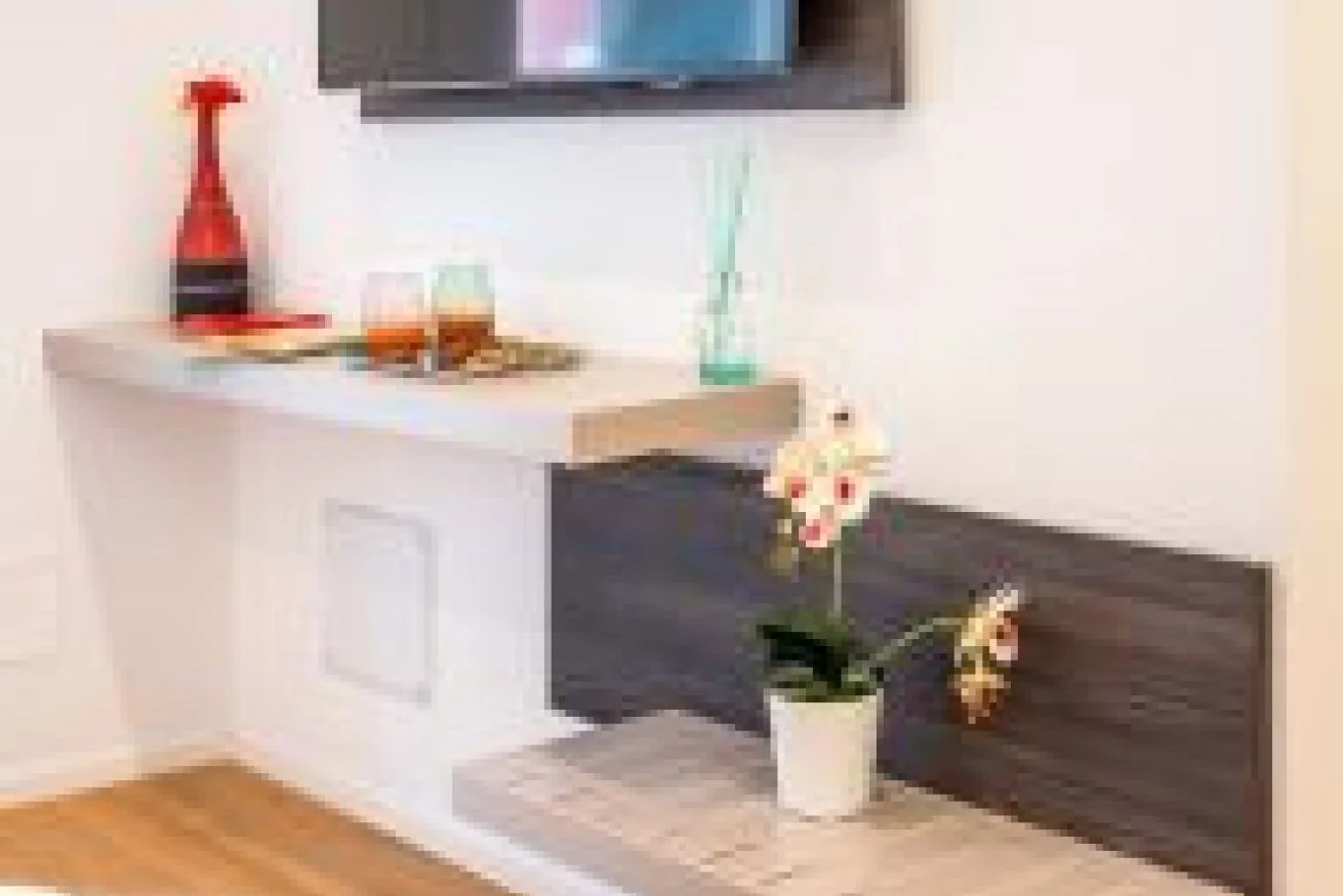 Una pequeña barra interior muestra bebidas junto a una planta con flores.