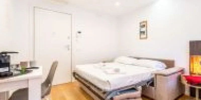 Un dormitorio con una cama junto a un escritorio y una silla.